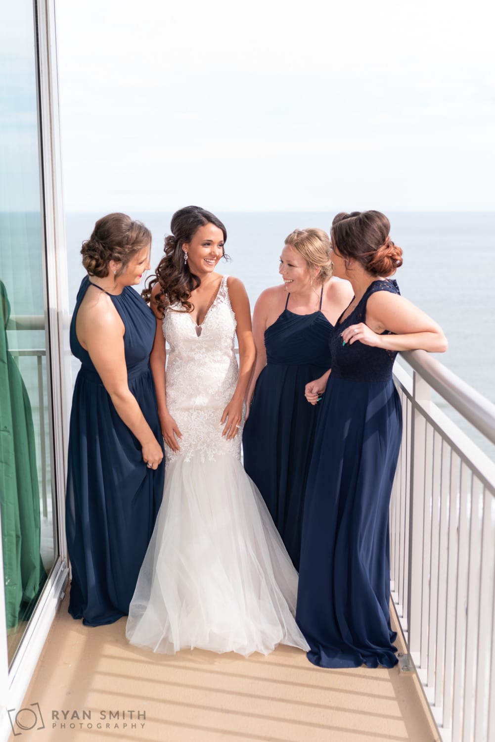 Bride and bridesmaids laughing on the balcony - Avista Resort - North Myrtle Beach