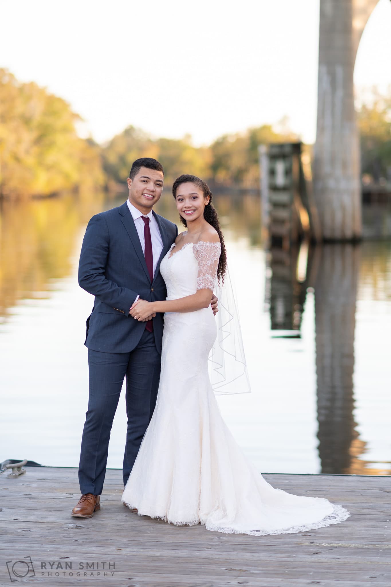 Bride and groom holding hands by the water - Conway Riverwalk