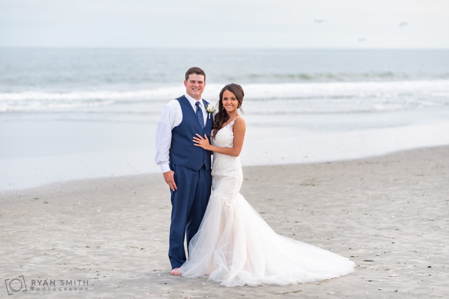 Bride and groom smiling in front of the ocean - Avista Resort - North Myrtle Beach