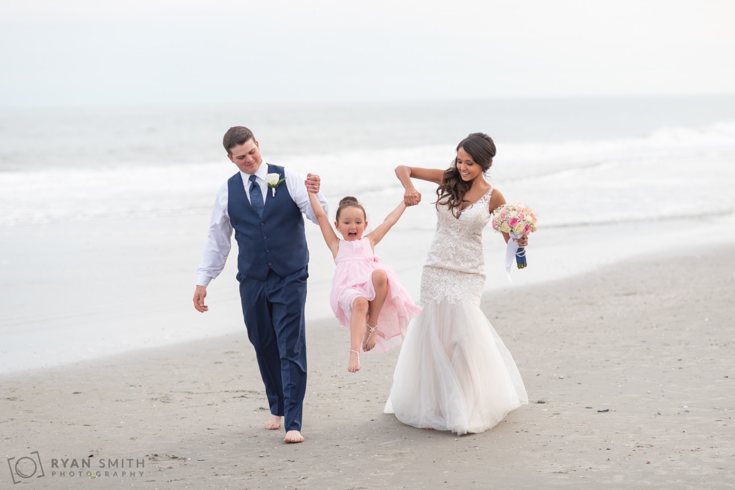 Bride and groom walking down the beach with their daughter - Avista Resort - North Myrtle Beach