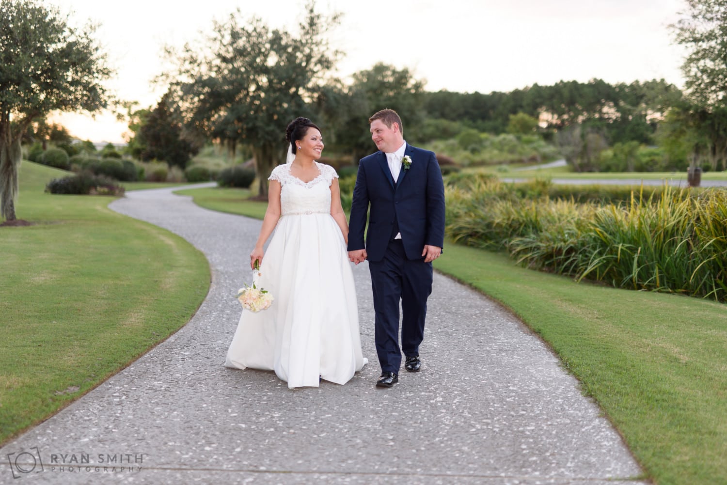 Bride and groom walking down the path - Dye Club at Barefoot Resort