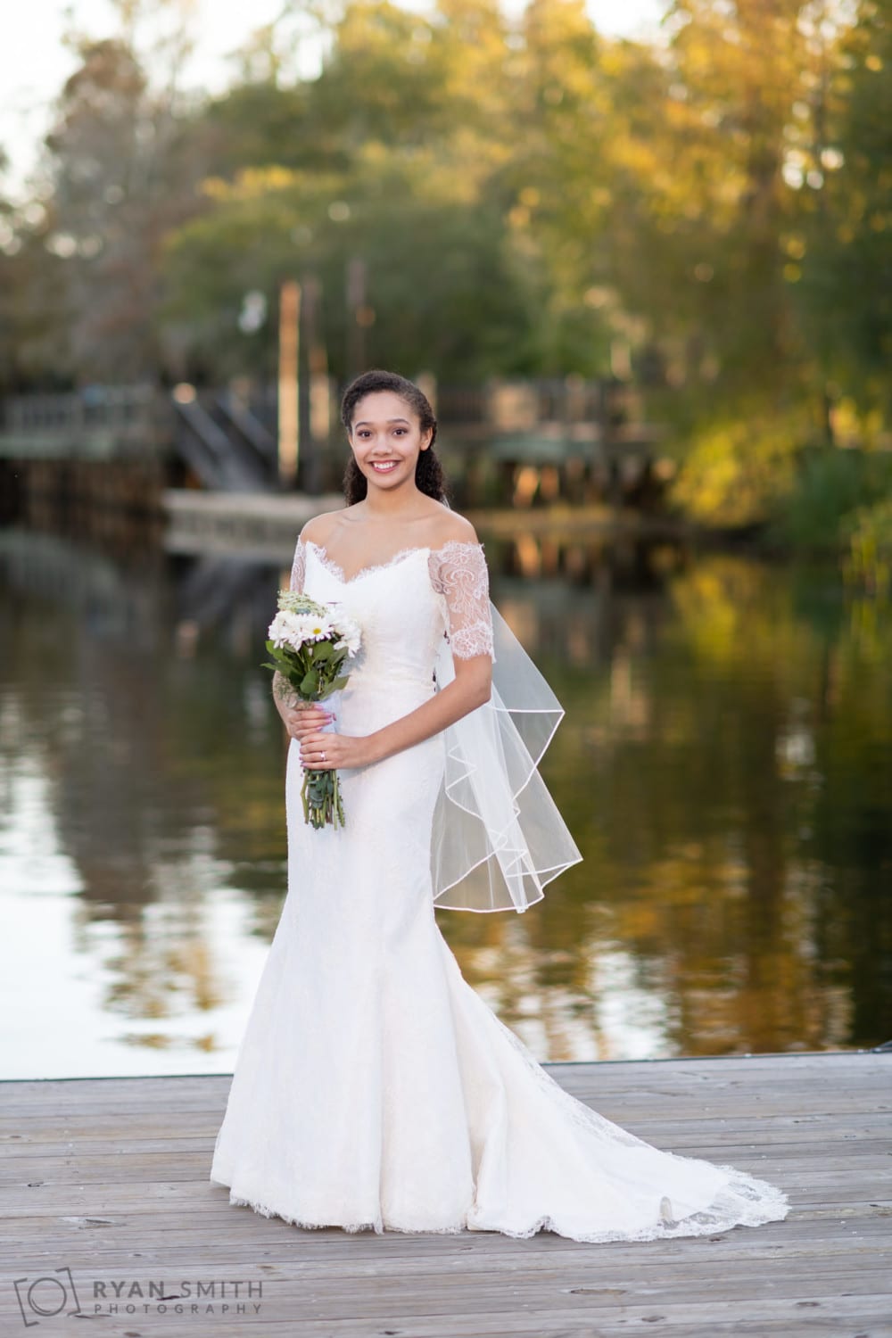 Bride holding flowers down on the dock - Conway Riverwalk