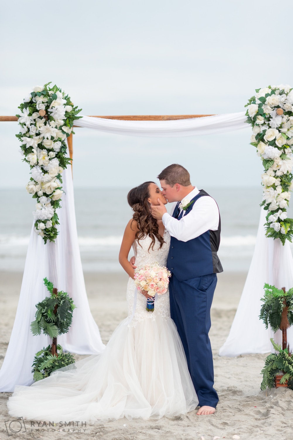 Kiss under the wedding arbor  - Avista Resort - North Myrtle Beach