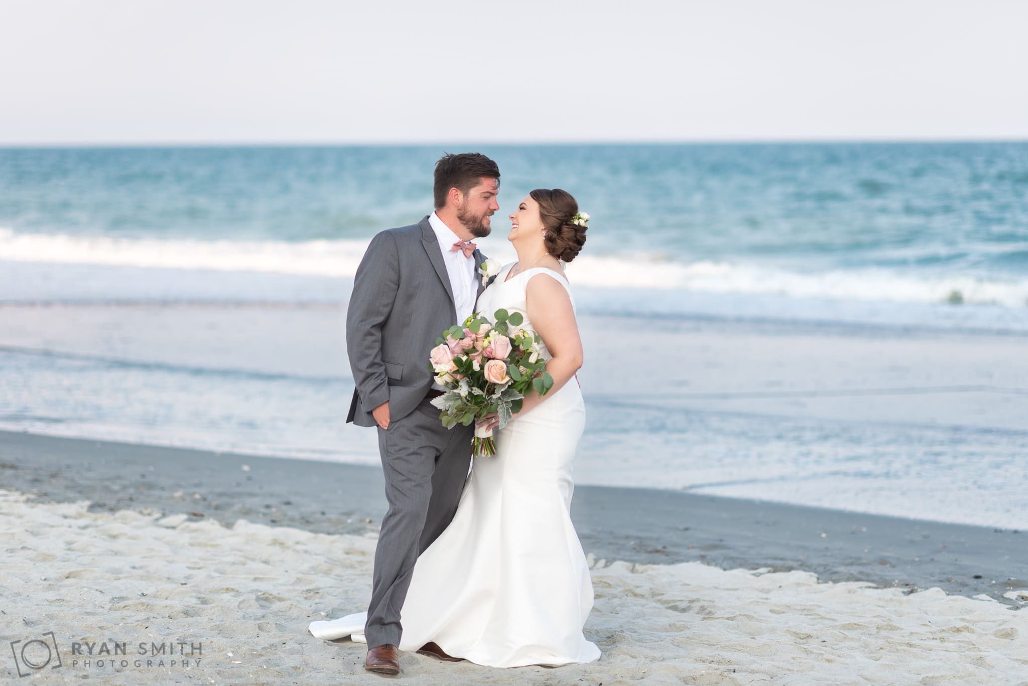 Bride and groom kissing in front of the ocean - Grande Dunes Ocean Club - Myrtle Beach