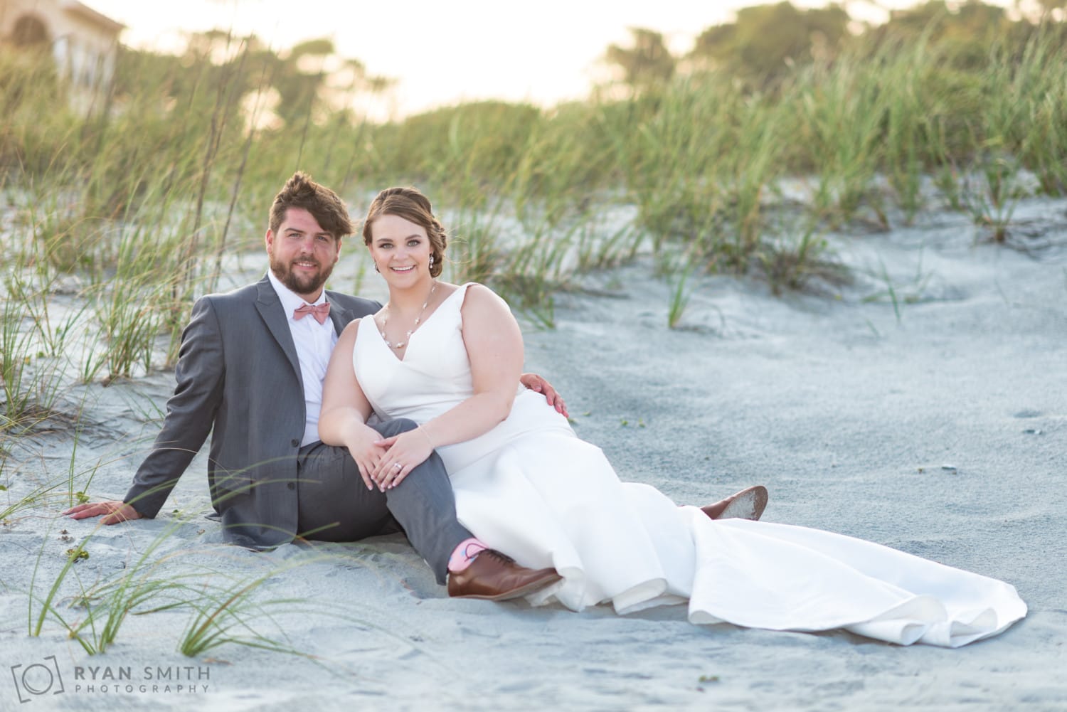 Bride and groom sitting by the dunes - Grande Dunes Ocean Club - Myrtle Beach