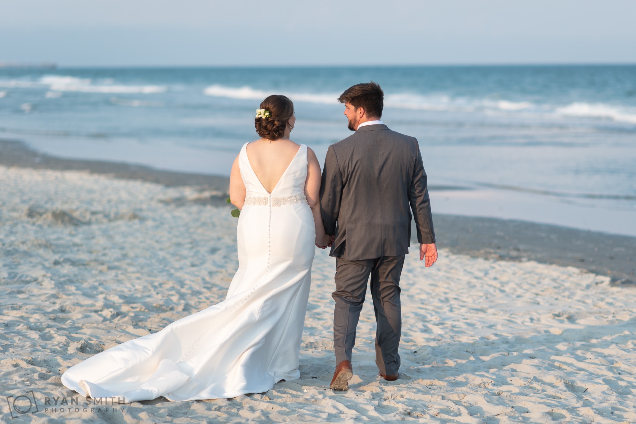 Bride and groom walking down the beach - Grande Dunes Ocean Club - Myrtle Beach