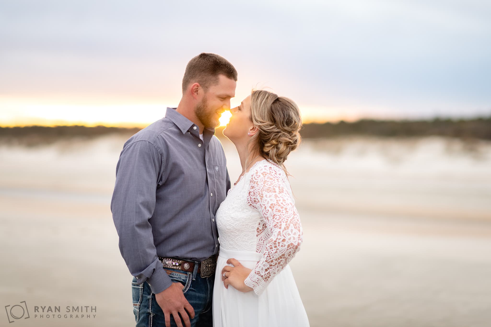 Engagement portrait in front of the setting sun - Huntington Beach State Park