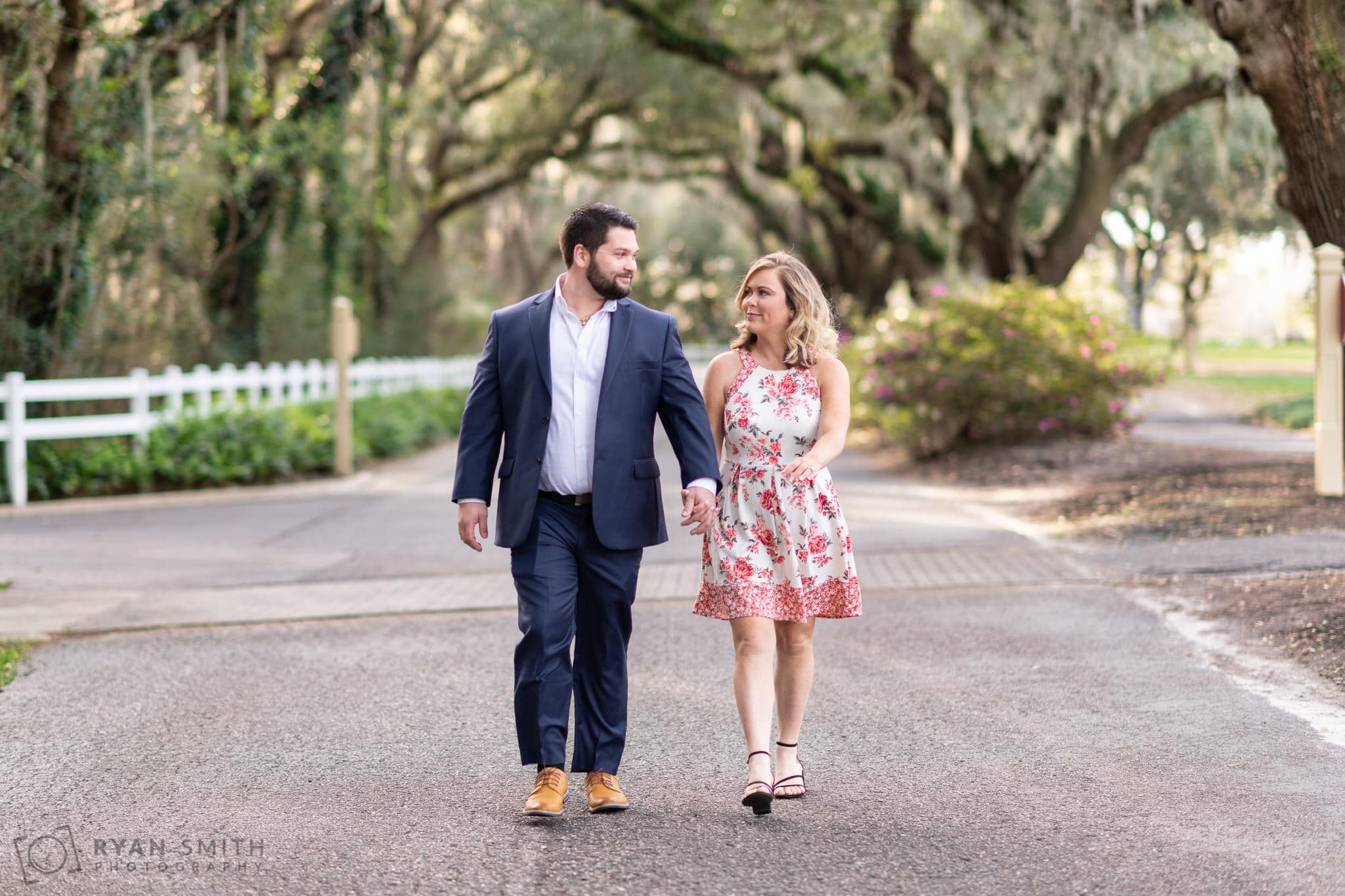 Holding hands walking under the live oaks - Caledonia Golf & Fish Club