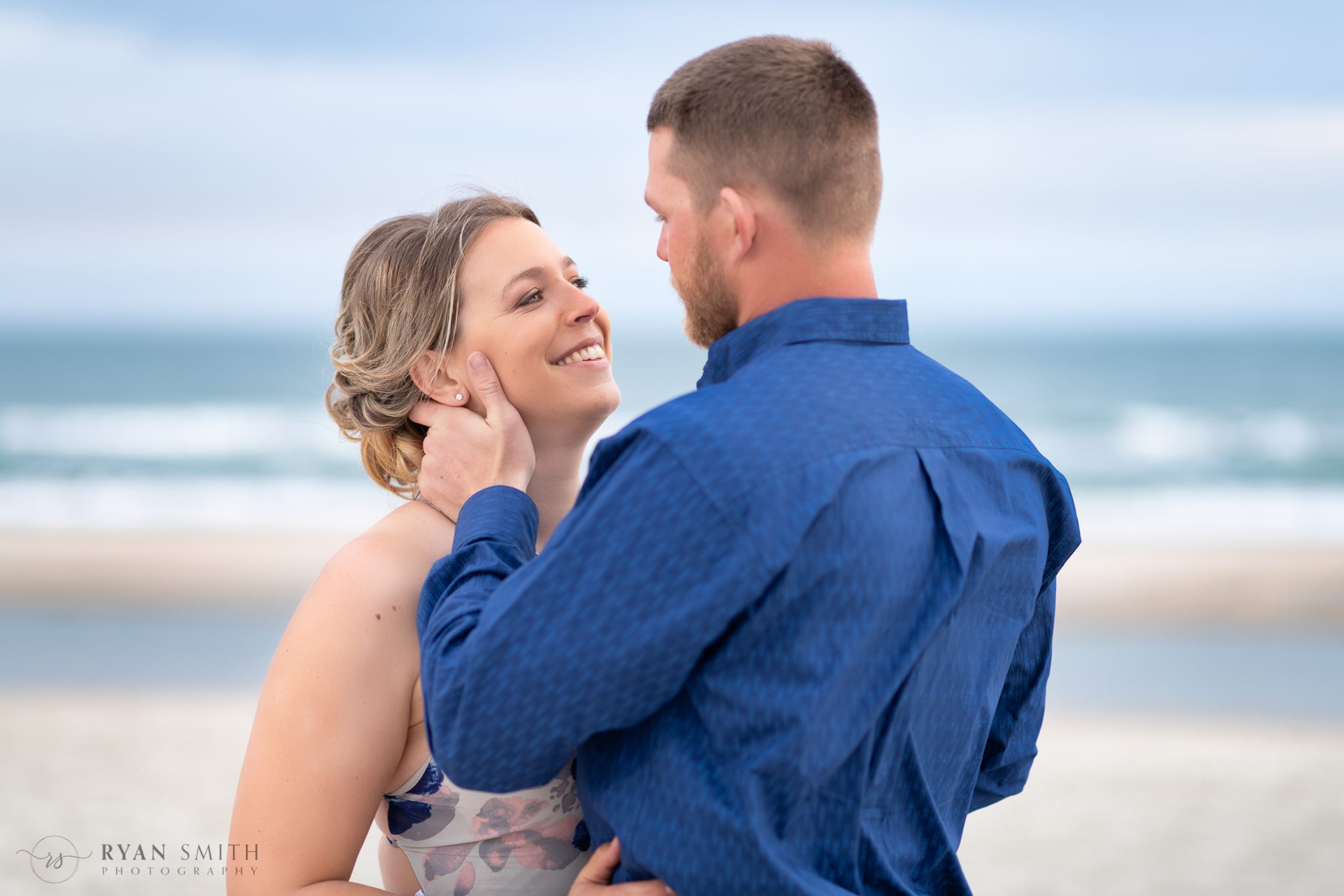 Smiling up at fiance in front of the ocean - Huntington Beach State Park