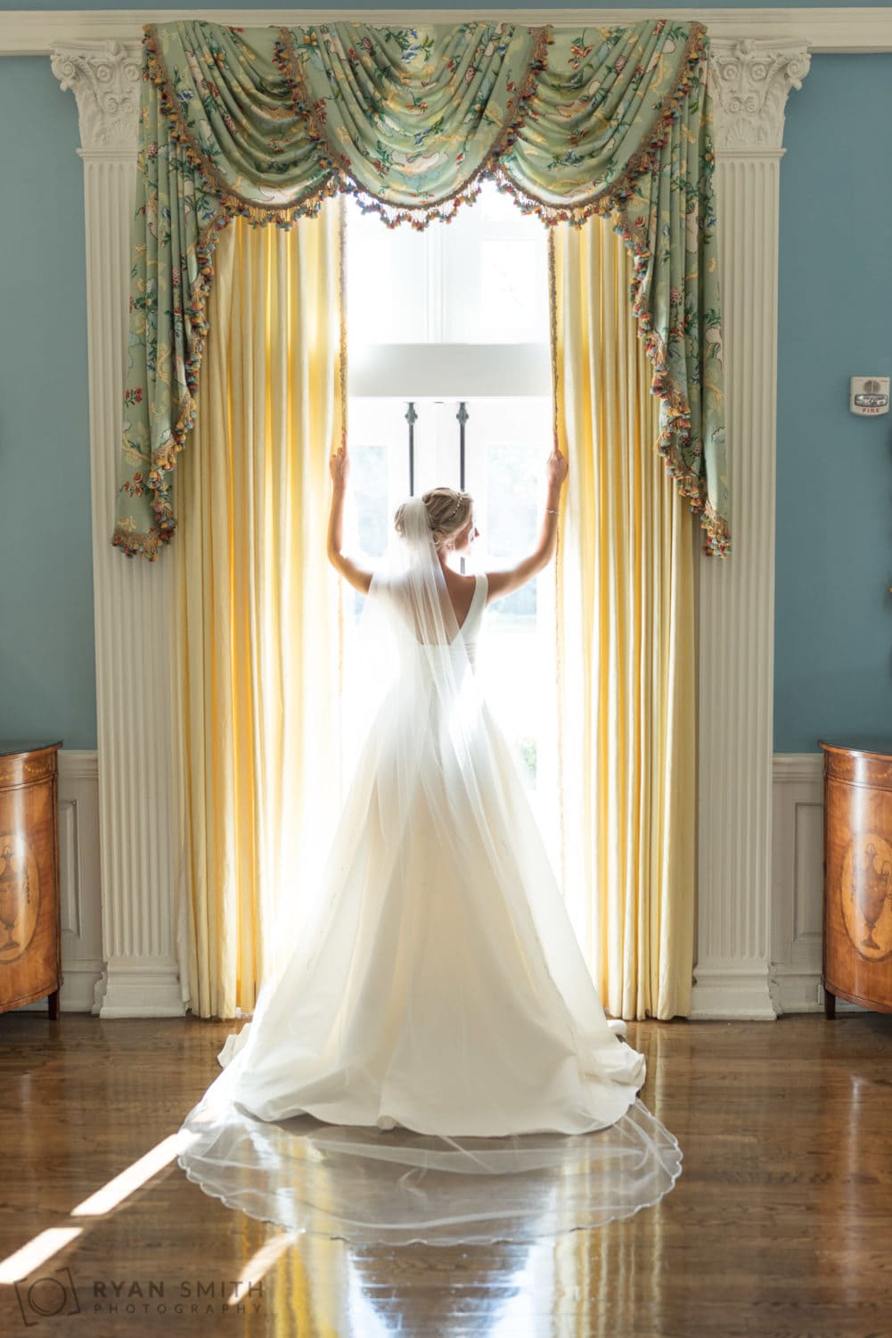Bride standing in the light from the window - Pine Lakes Country Club