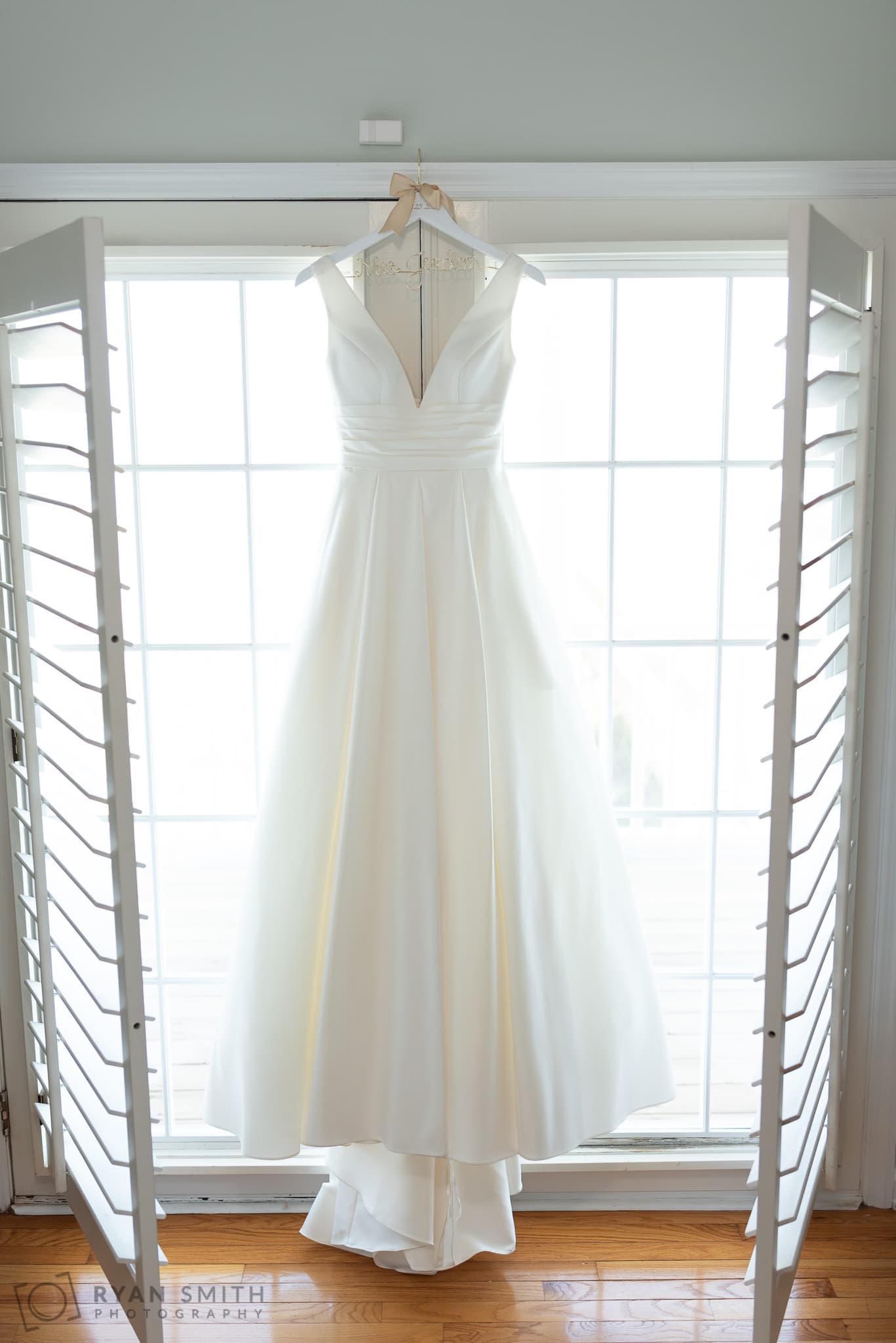 Wedding dress hanging in window -