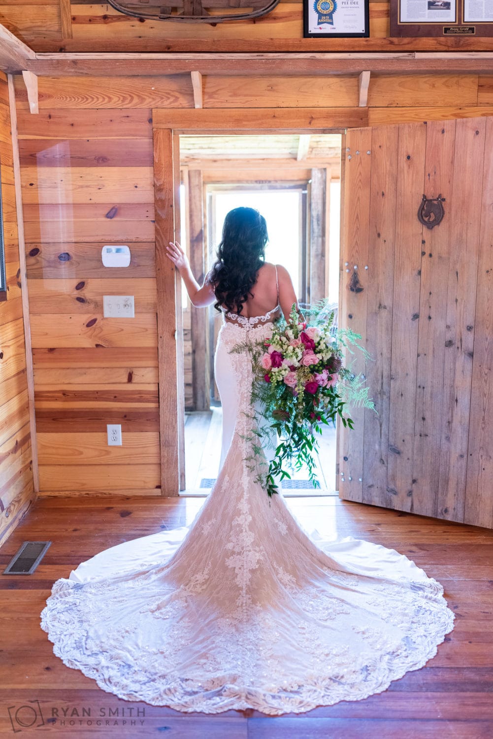 Bride holding flowers in doorway - Hidden Acres