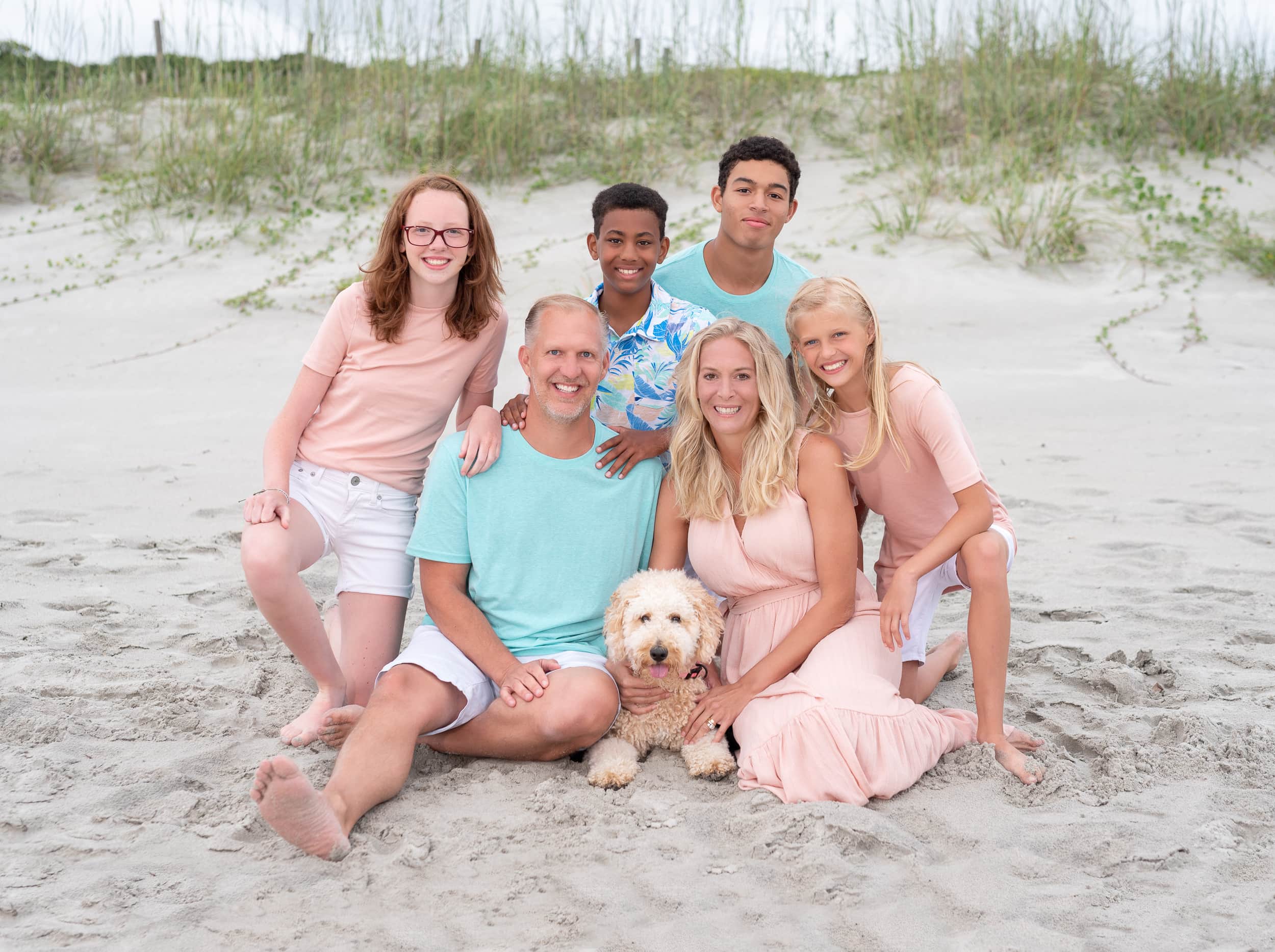 Cute family with their dog sitting in front of the dunes - Myrtle Beach State Park