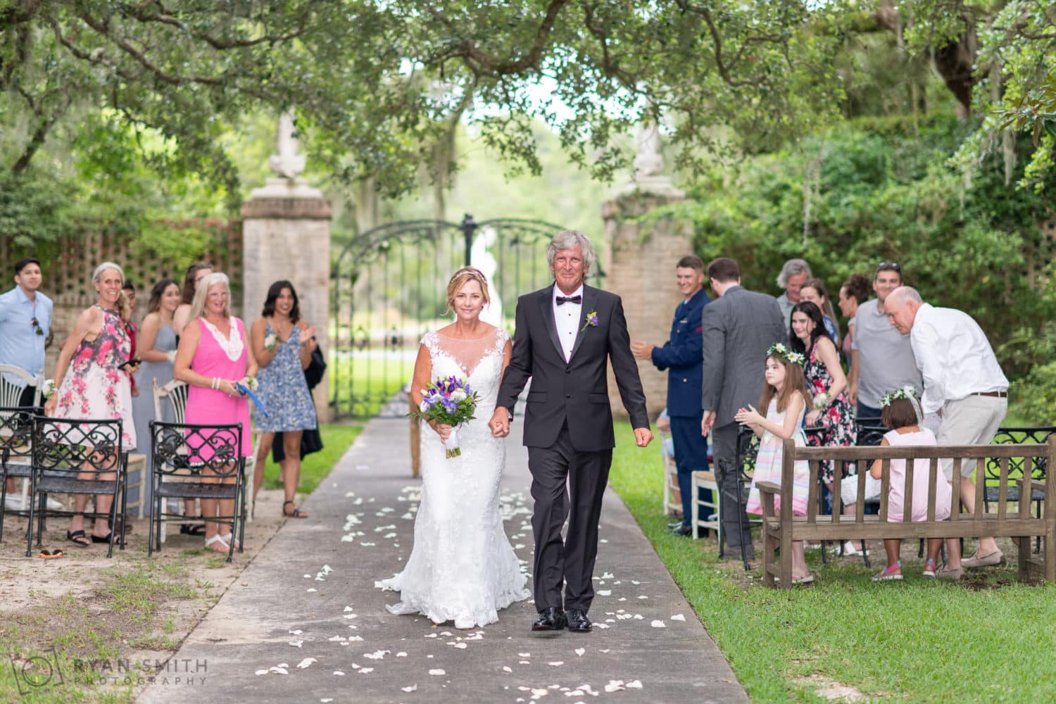 Bride and groom walking from the ceremony - Holiday Cottage - Brookgreen Gardens
