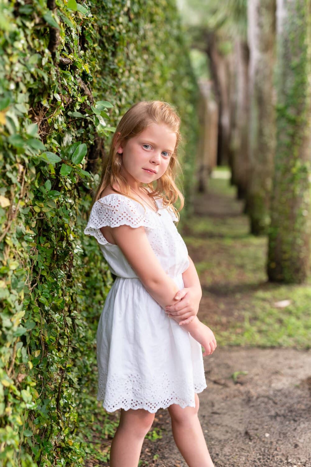Little girl posing by the castle wall ivy - Huntington Beach State Park