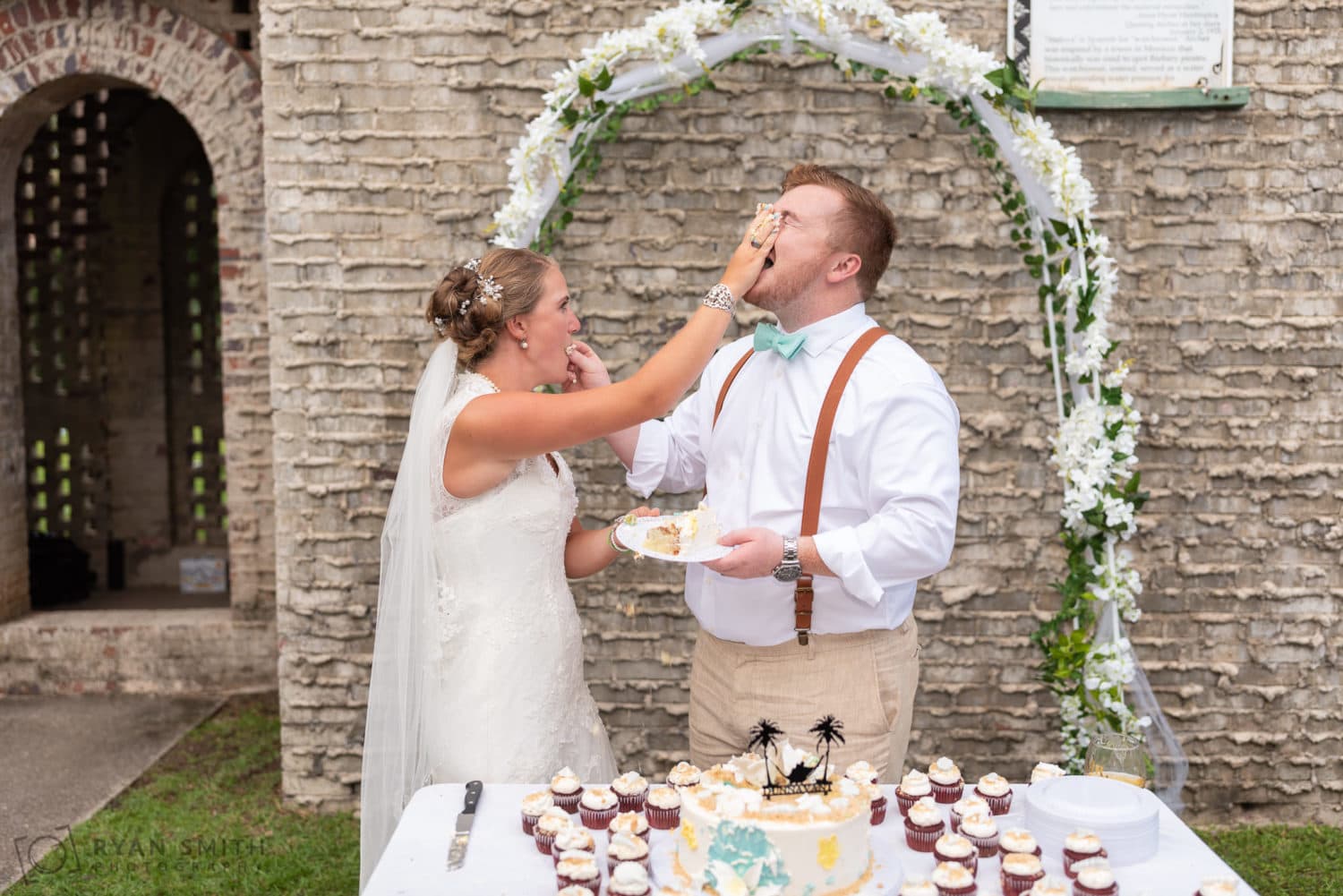 Bride smashing cake in the face of the groom - Atalaya Castle - Huntington Beach State Park