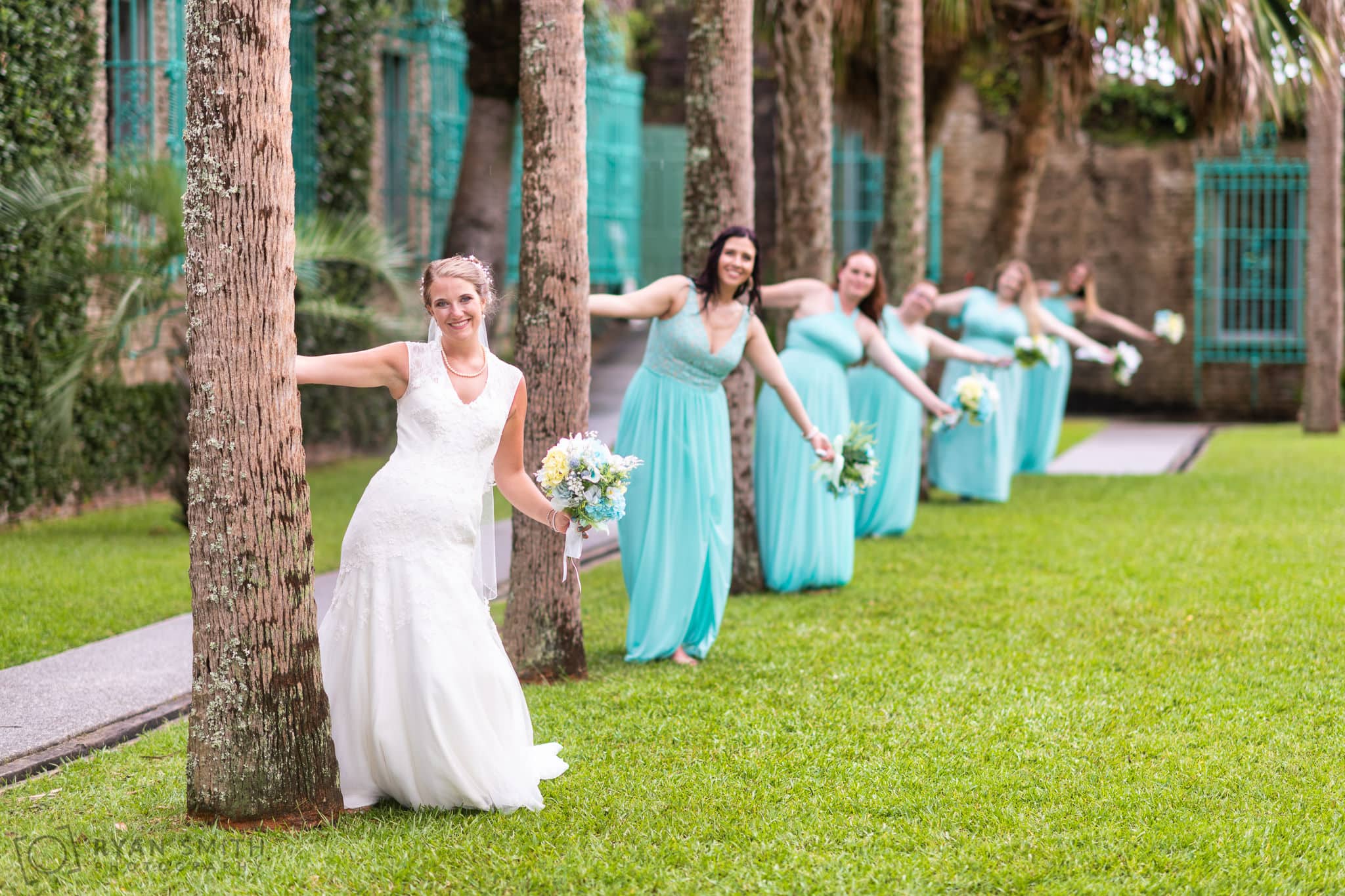Fun picture with bridesmaids leaning out from behind the trees - Atalaya Castle - Huntington Beach State Park