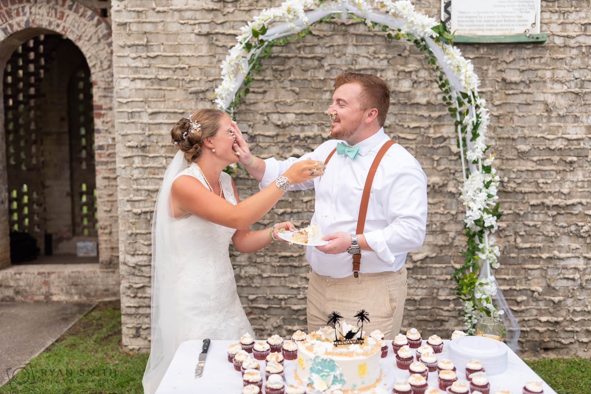 Groom smashing cake in the face of the bride - Atalaya Castle - Huntington Beach State Park