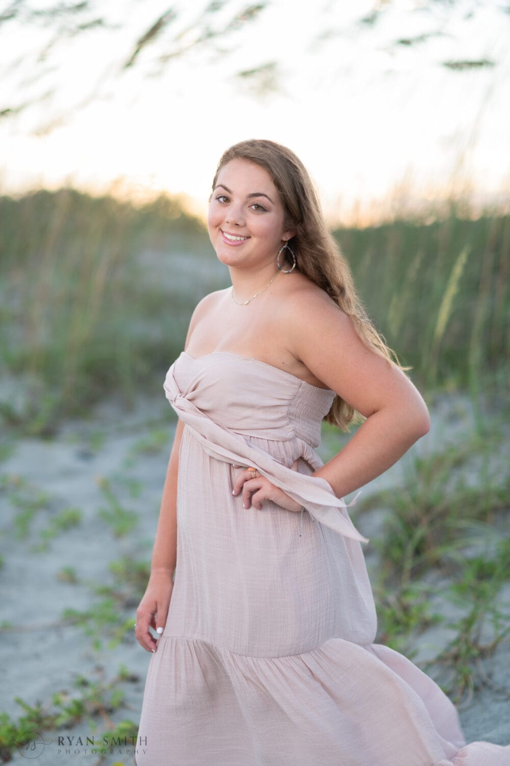 Senior in front of the sea oats and sunset - Huntington Beach State Park