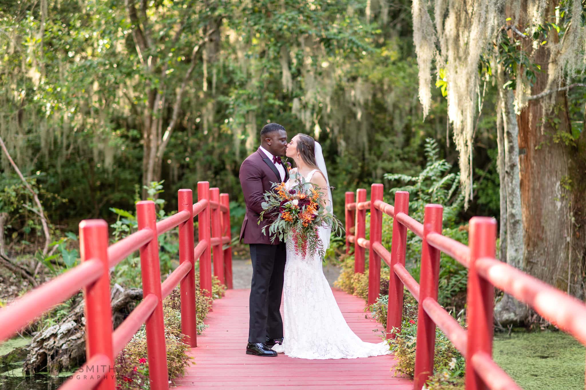 Bride and groom kissing on the red bridge - Magnolia Plantation - Charleston, SC