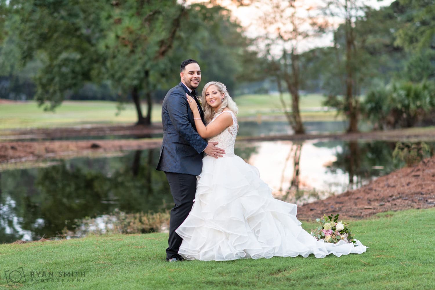 Portraits of the bride and groom in front of the golf course lake - Litchfield Country Club