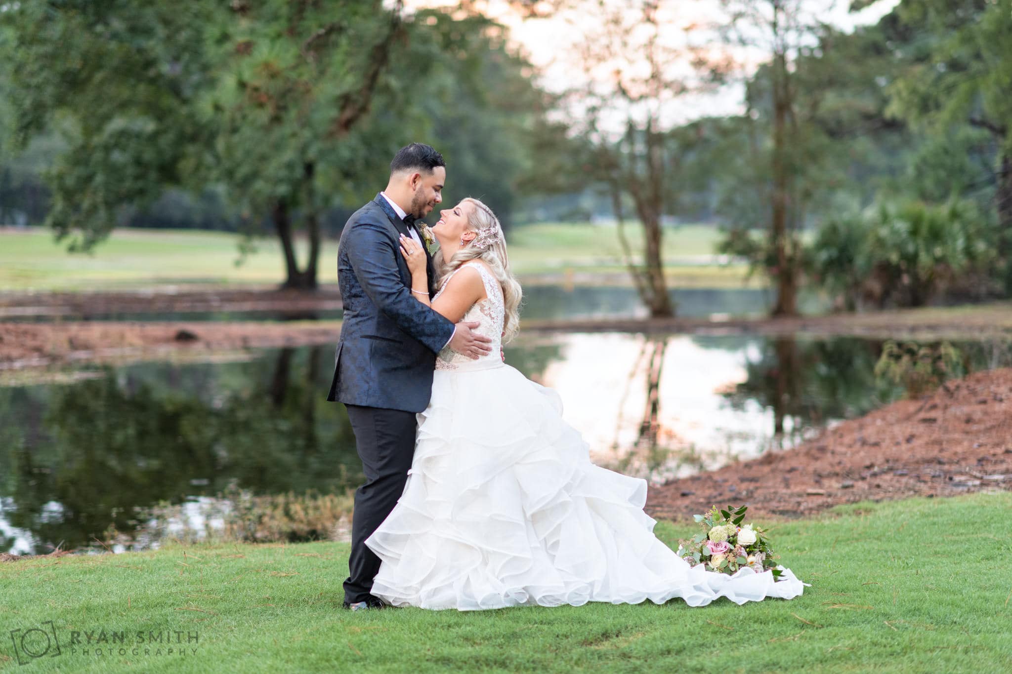 Portraits of the bride and groom in front of the golf course lake - Litchfield Country Club