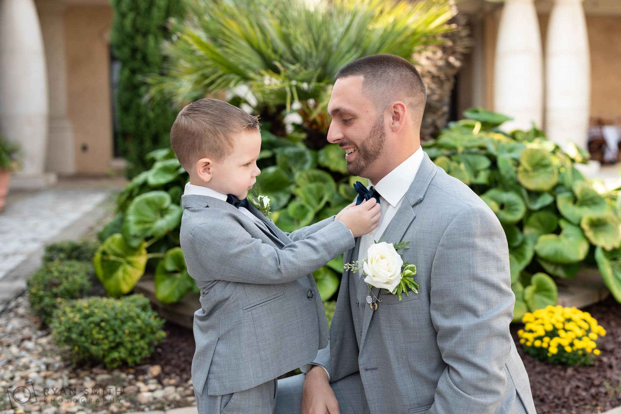 Ring bearer helping groom with his tie - 21 Main Events - North Myrtle Beach