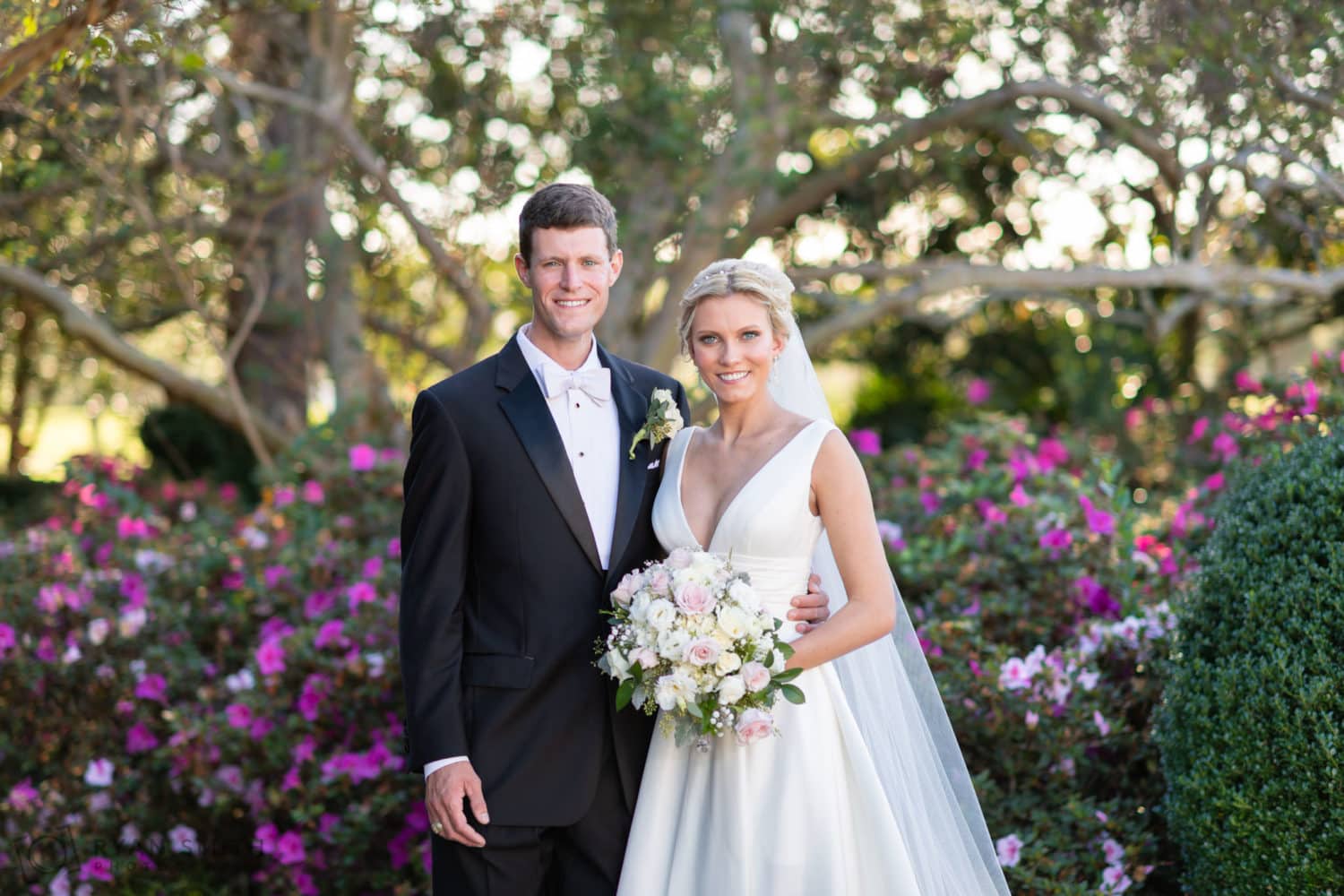 Bride and groom standing in front of the garden trees - Pine Lakes Country Club