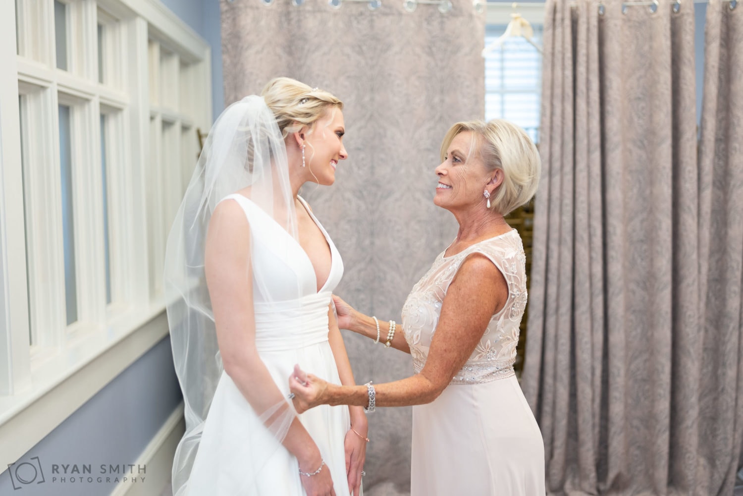 Mom pulling bride's veil over her shoulders  - Pine Lakes Country Club
