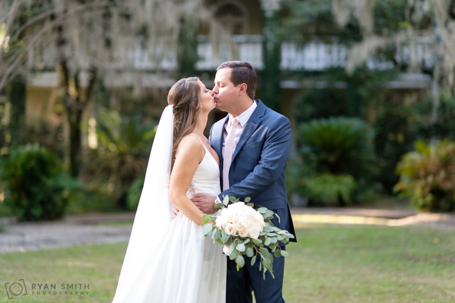 Bride and groom in front of the ivy covered house - Oak Allee - Wachesaw Plantation