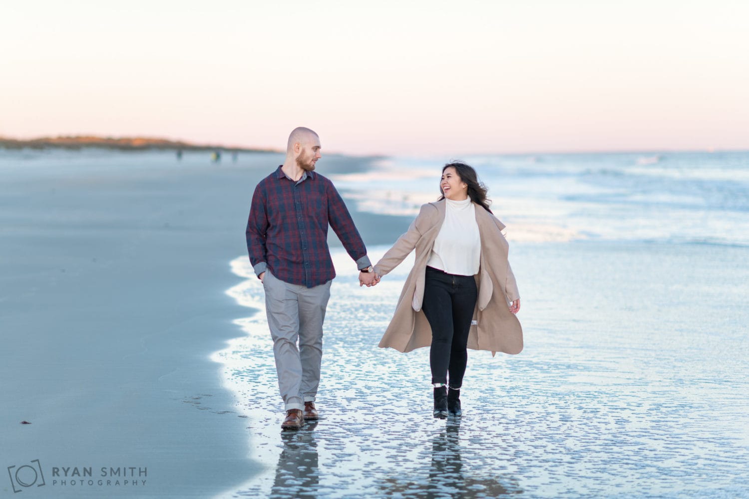 Engaged couple walking down the beach together - Huntington Beach State Park
