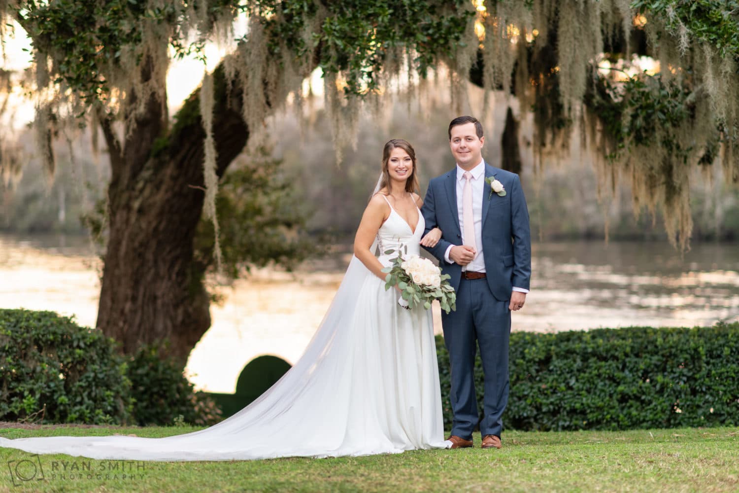 Formal portrait of bride and groom by the river - Kimbel's - Wachesaw Plantation