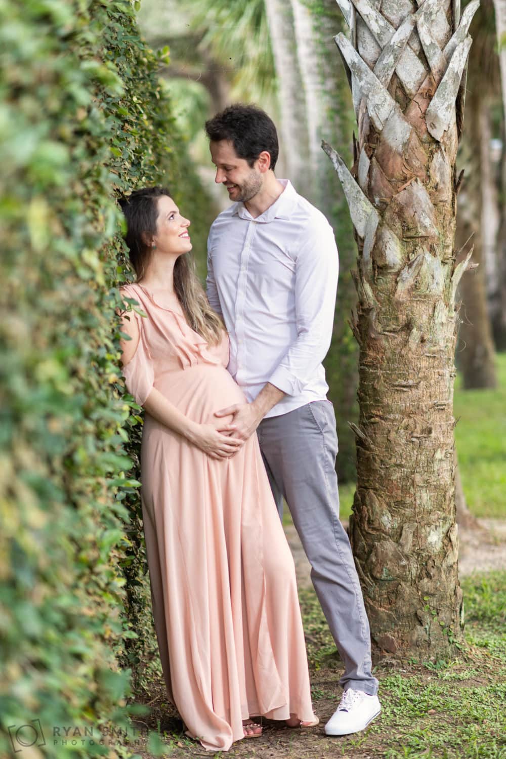 Husband and wife taking maternity portraits by the ivy wall - Atalaya Castle