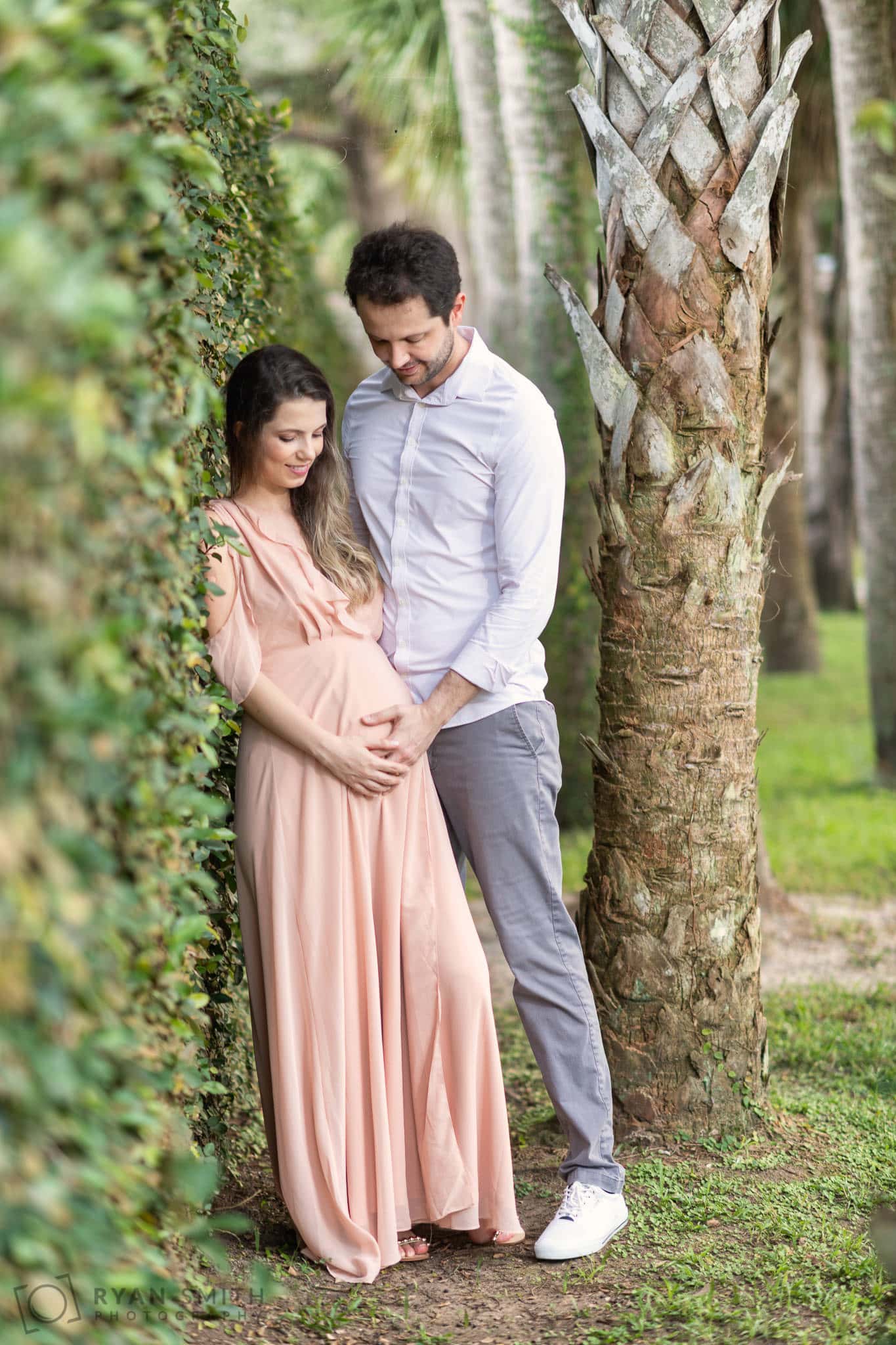 Husband and wife taking maternity portraits by the ivy wall - Atalaya Castle