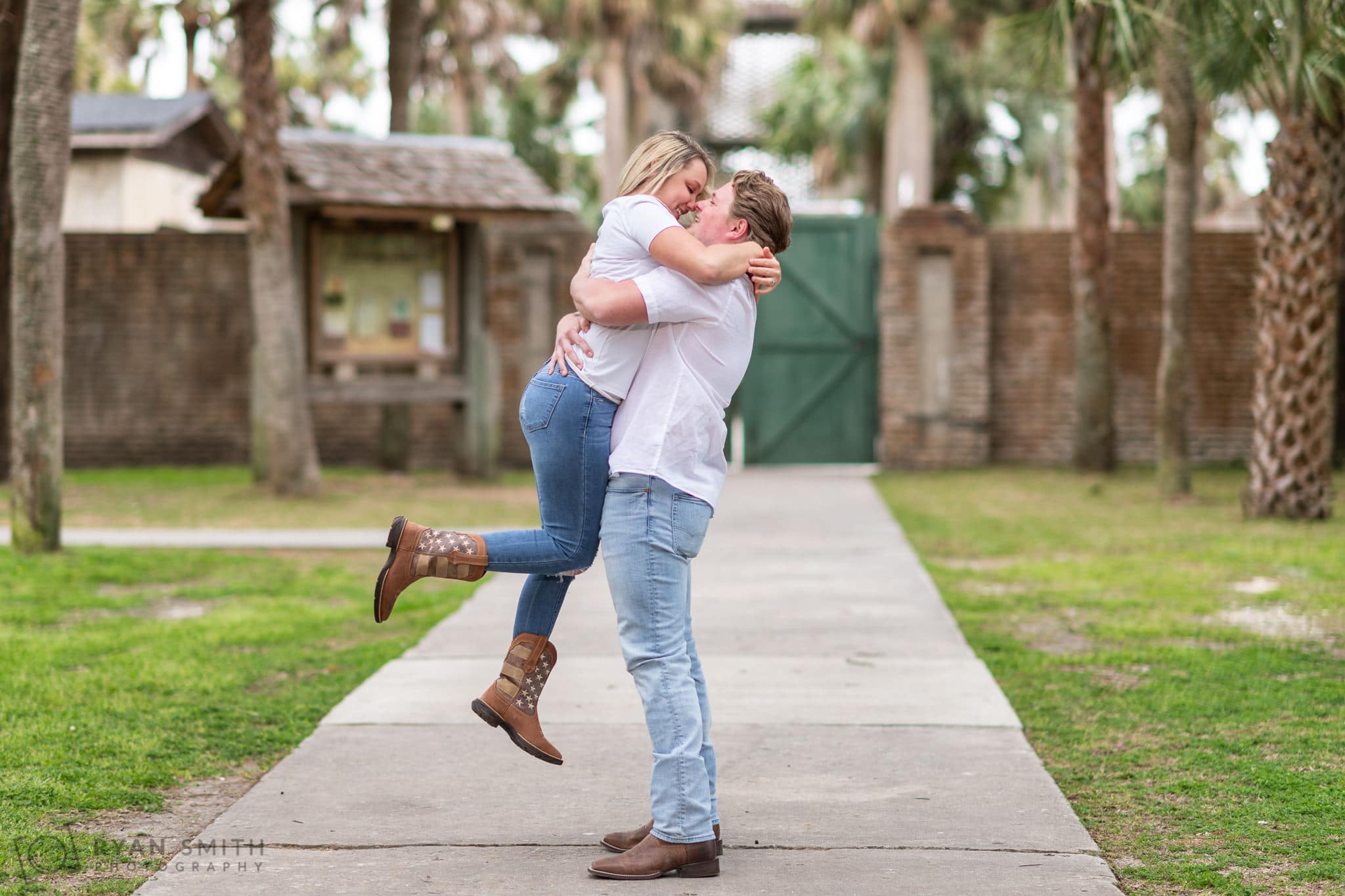 Lifting fiance into the air in front of the castle - Huntington Beach State Park
