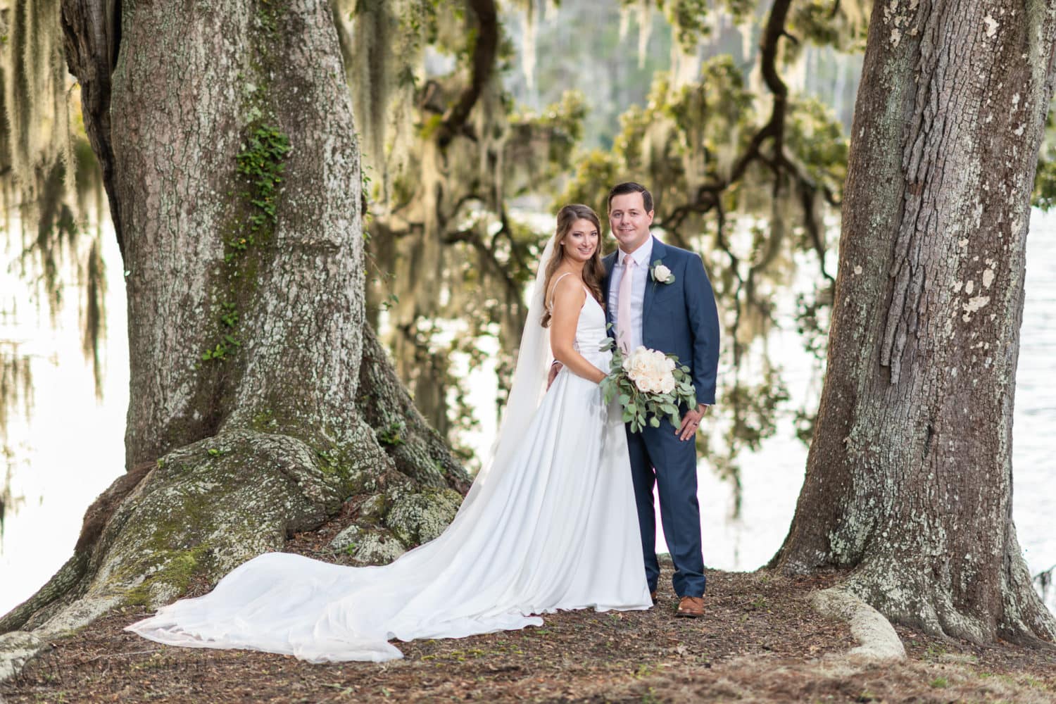 Portraits of bride and groom between the two large oaks on the river - Kimbel's - Wachesaw Plantation