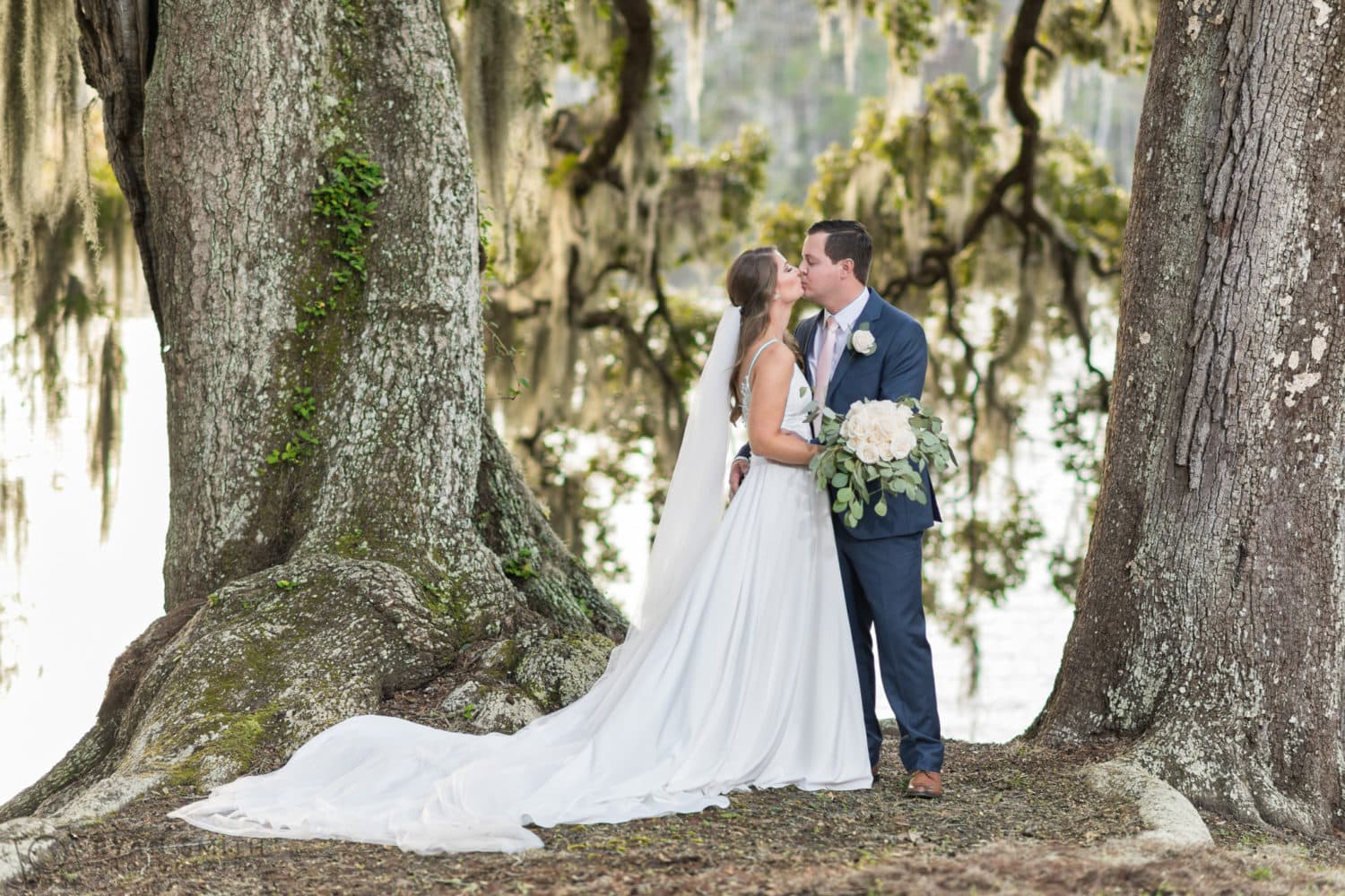 Portraits of bride and groom between the two large oaks on the river - Kimbel's - Wachesaw Plantation