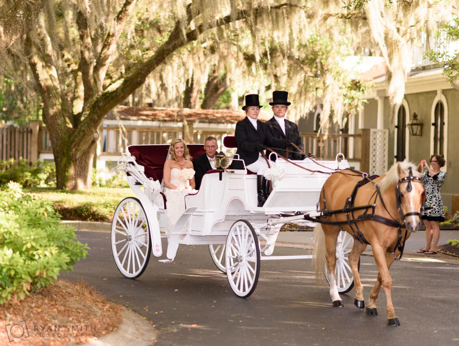 Bride and father arriving on horse drawn carriage to ceremony - Wachesaw Plantation