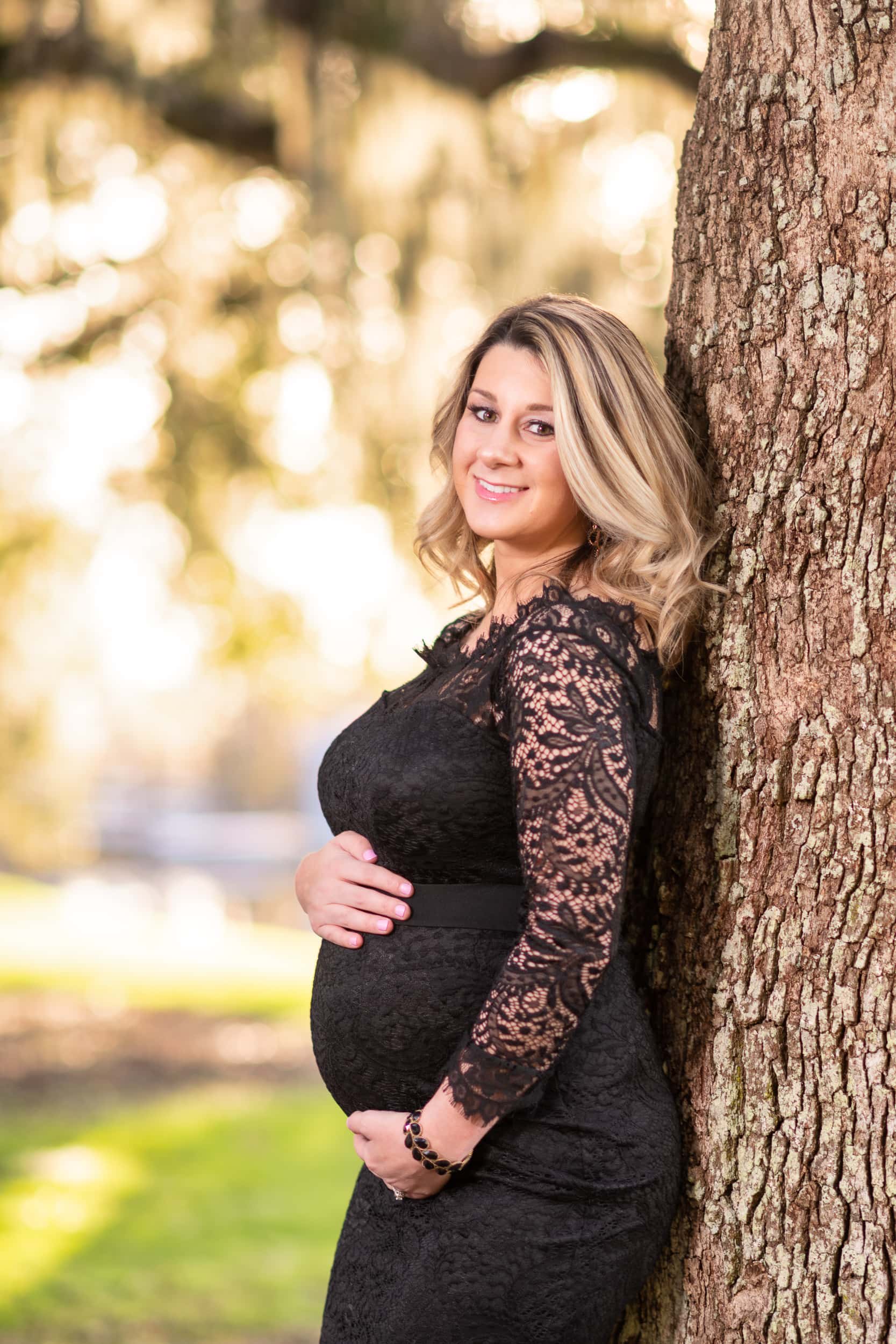 Expectant mother leaning against a tree in front of the moss - Caledonia Golf & Fish Club