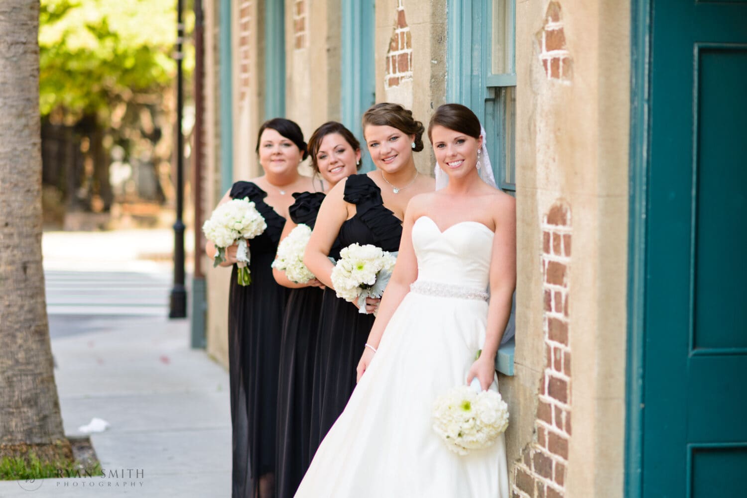 Bride and bridesmaids leaning against the window - Downtown Charleston, SC