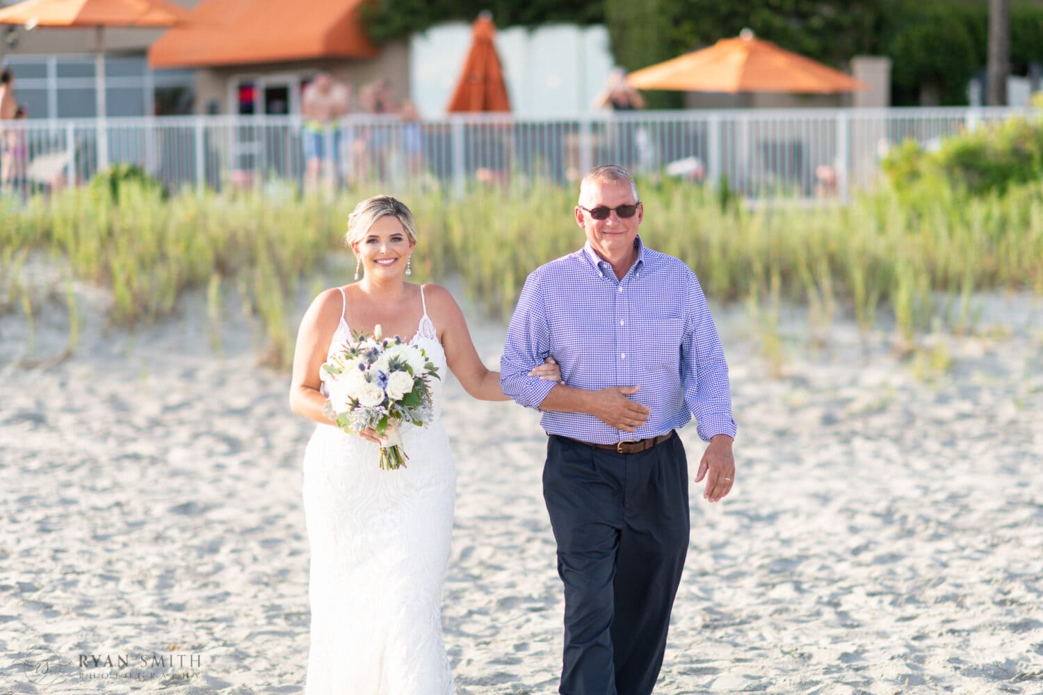 Bride and father walking to the ceremony on the beach - Folly Beach - Charleston