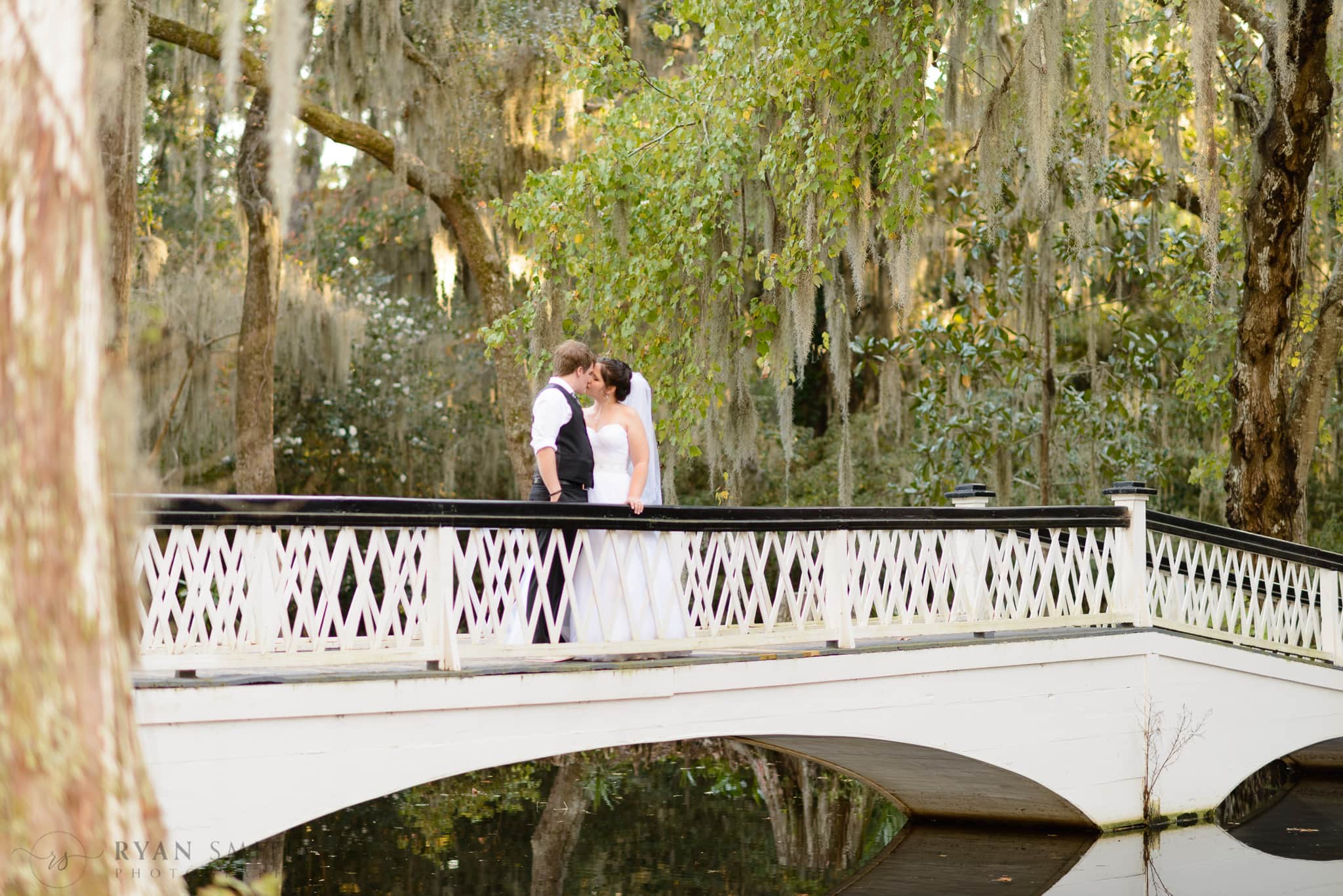 Bride and groom standing on the white bridge - Magnolia Plantation