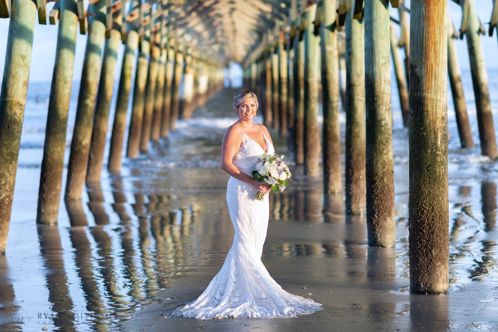Bride holding bouquet under the pier - Folly Beach - Charleston