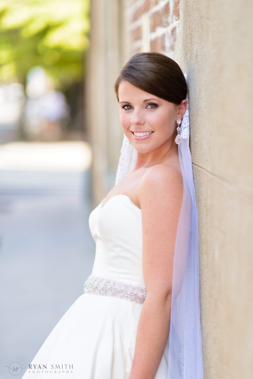 Bride leaning against the brick wall - Charleston, SC