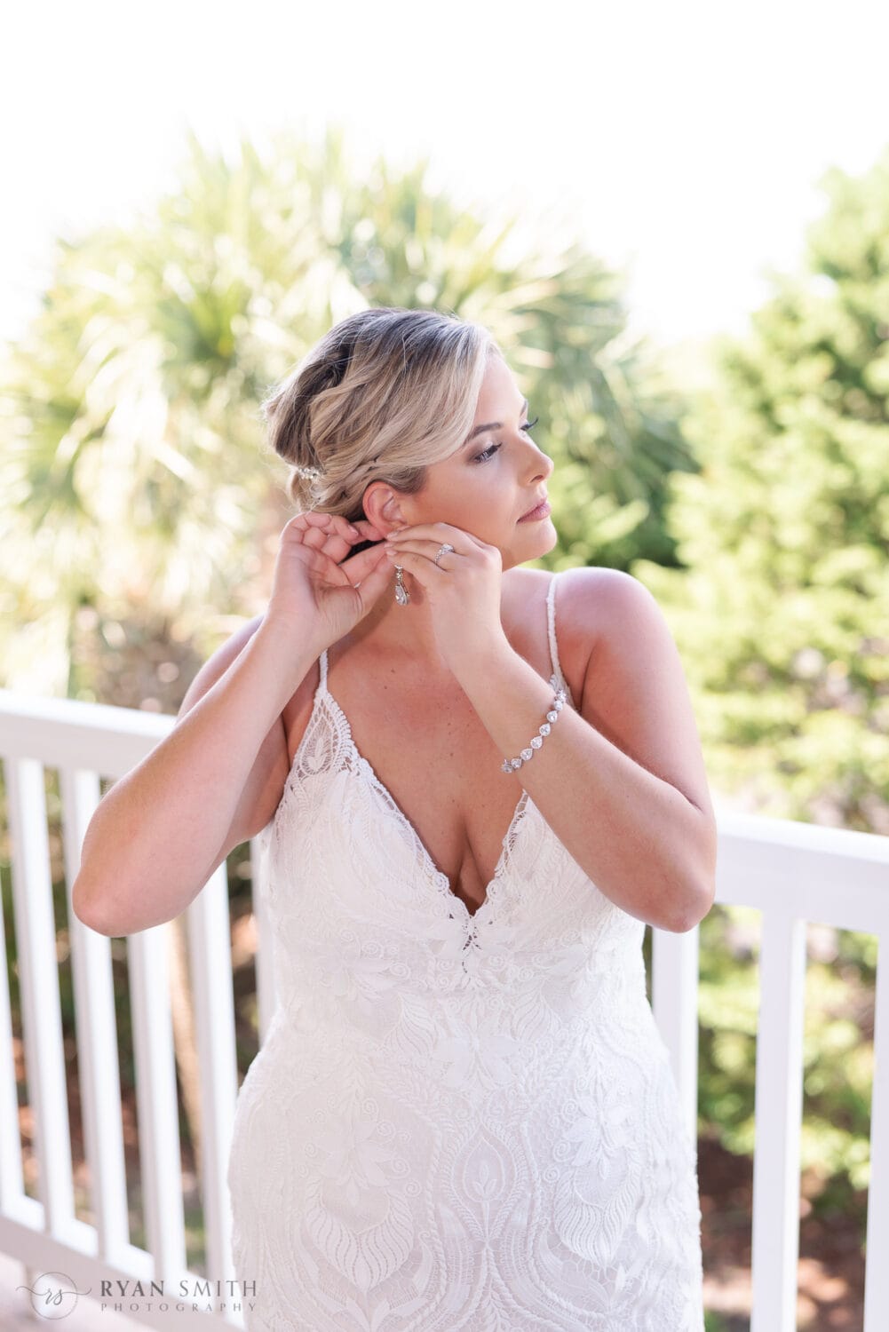 Bride putting on her earrings  - Folly Beach - Charleston