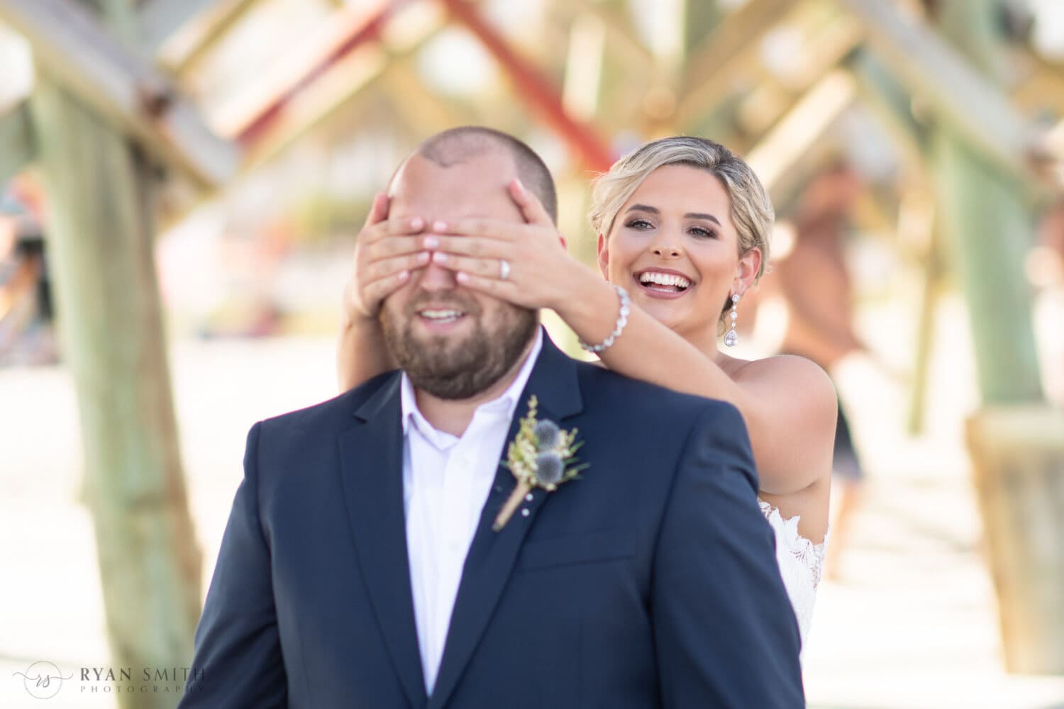 First look with bride putting her hands around the groom's eyes - Folly Beach - Charleston