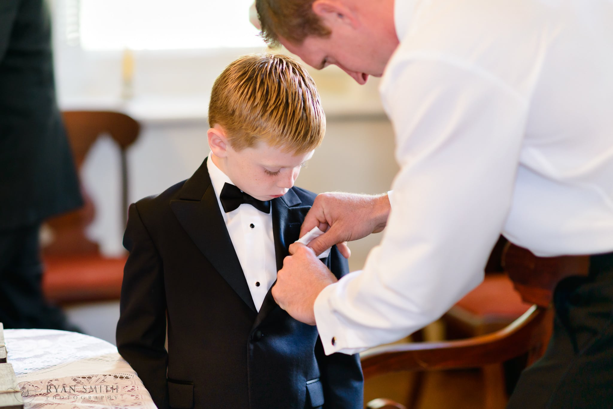 Groom putting in ring bearer's pocket square  - Downtown Charleston, SC