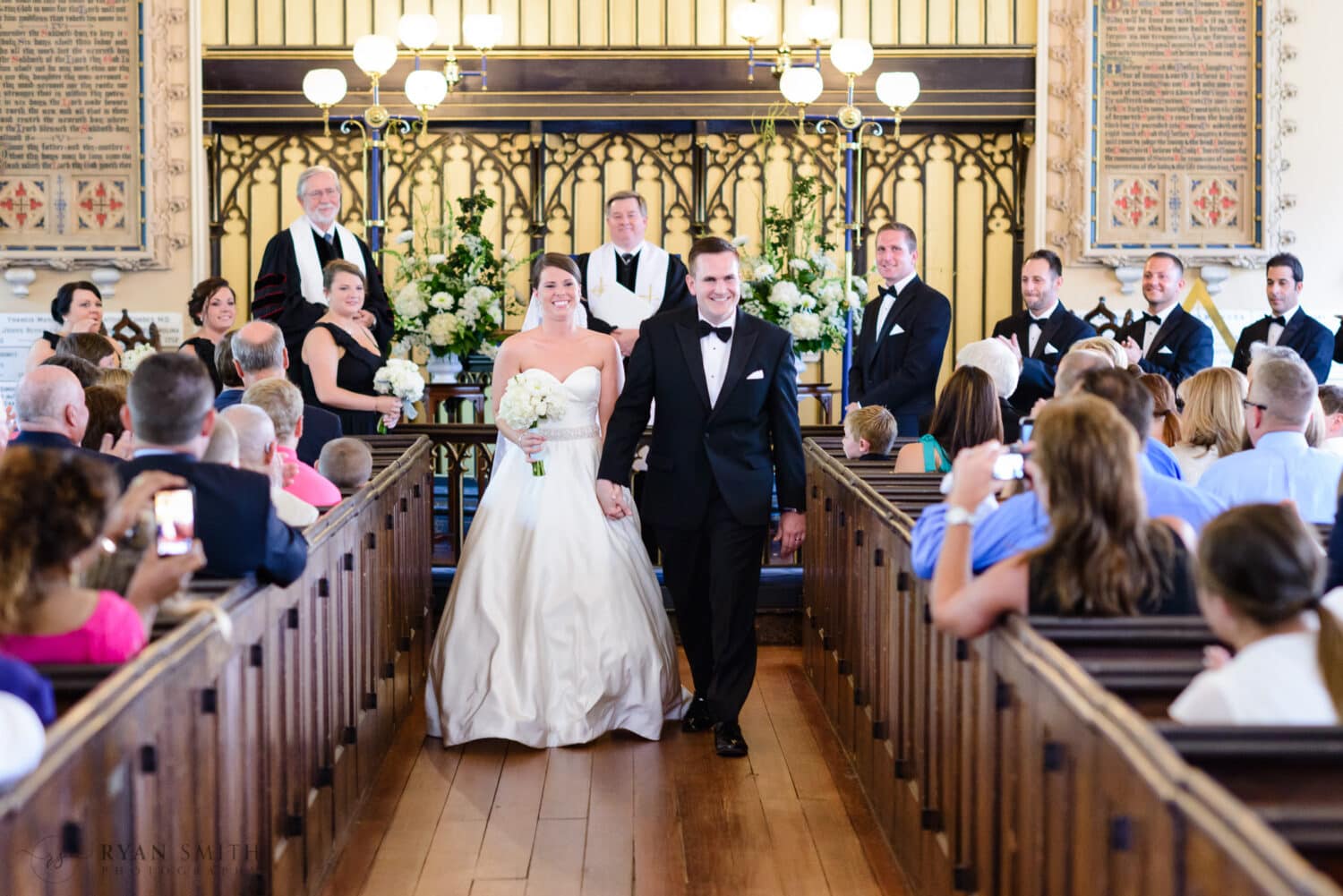 Happy bride and groom walking down the aisle together - French Huguenot Protestant Church