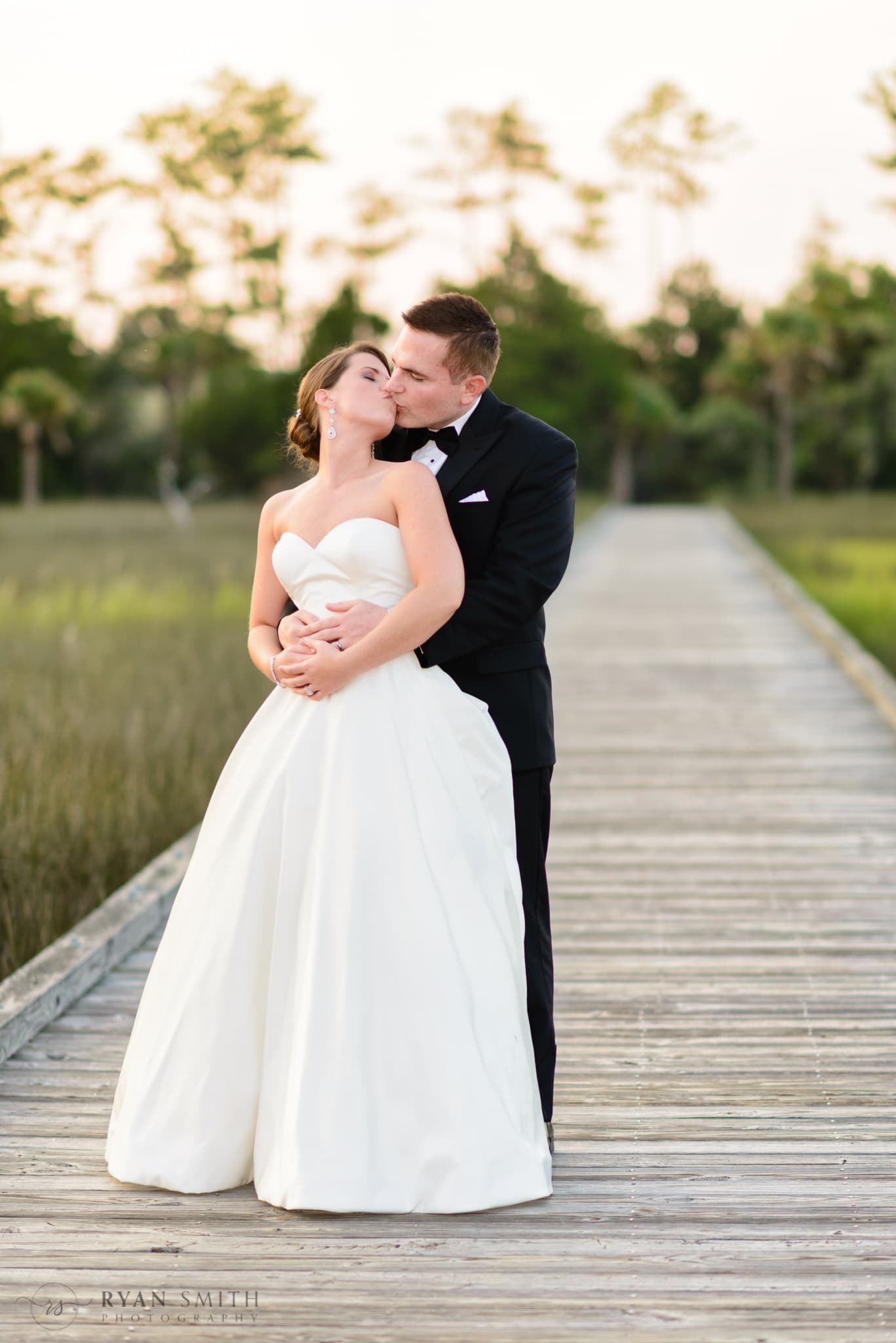 Portraits of the bride and groom at sunset on the marsh boardwalk - Daniel Island Club - Charleston, SC