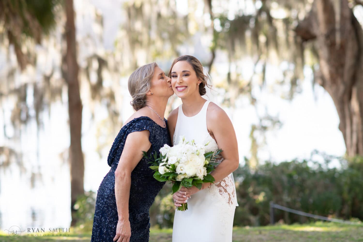 Mom kissing bride on the cheek - Kimbels at Wachesaw Plantation